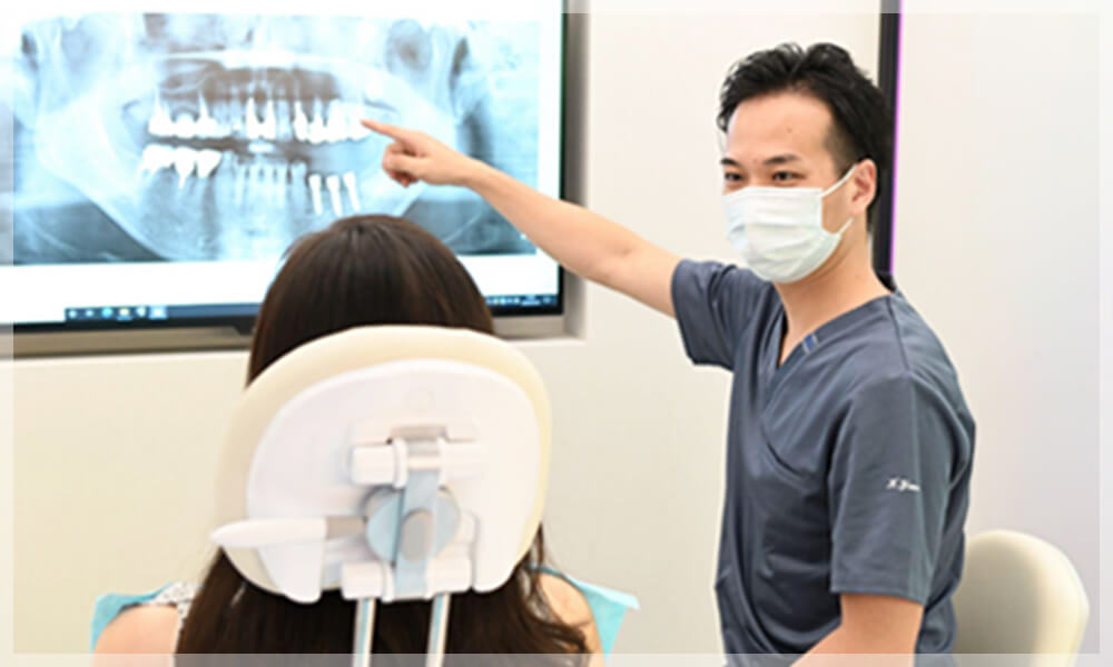 患者に治療内容を説明する歯科医師